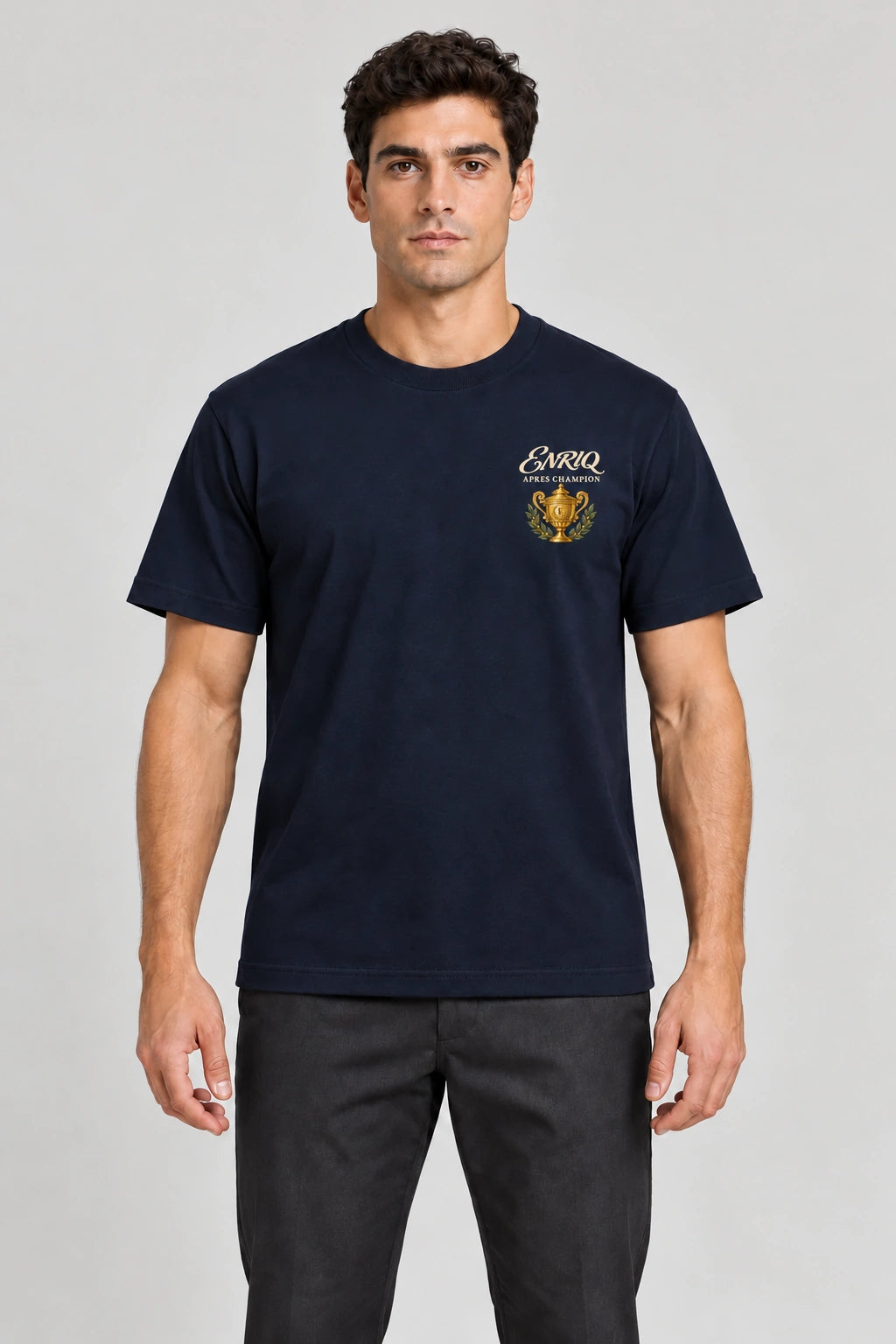 ENRIQ Apres Champion Tee Navy – op model met gouden trofee-borstlogo (AI-visualisatie)