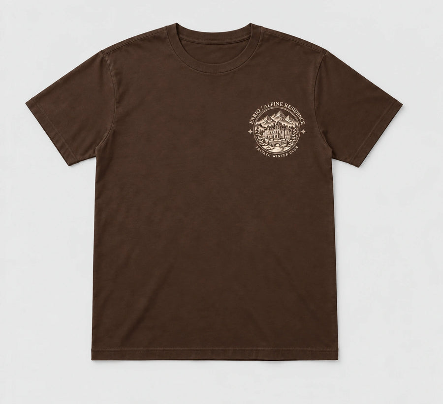 ENRIQ Alpine Residence Tee Cocoa – flatlay met rond landhuis-borstlogo (AI-visualisatie)