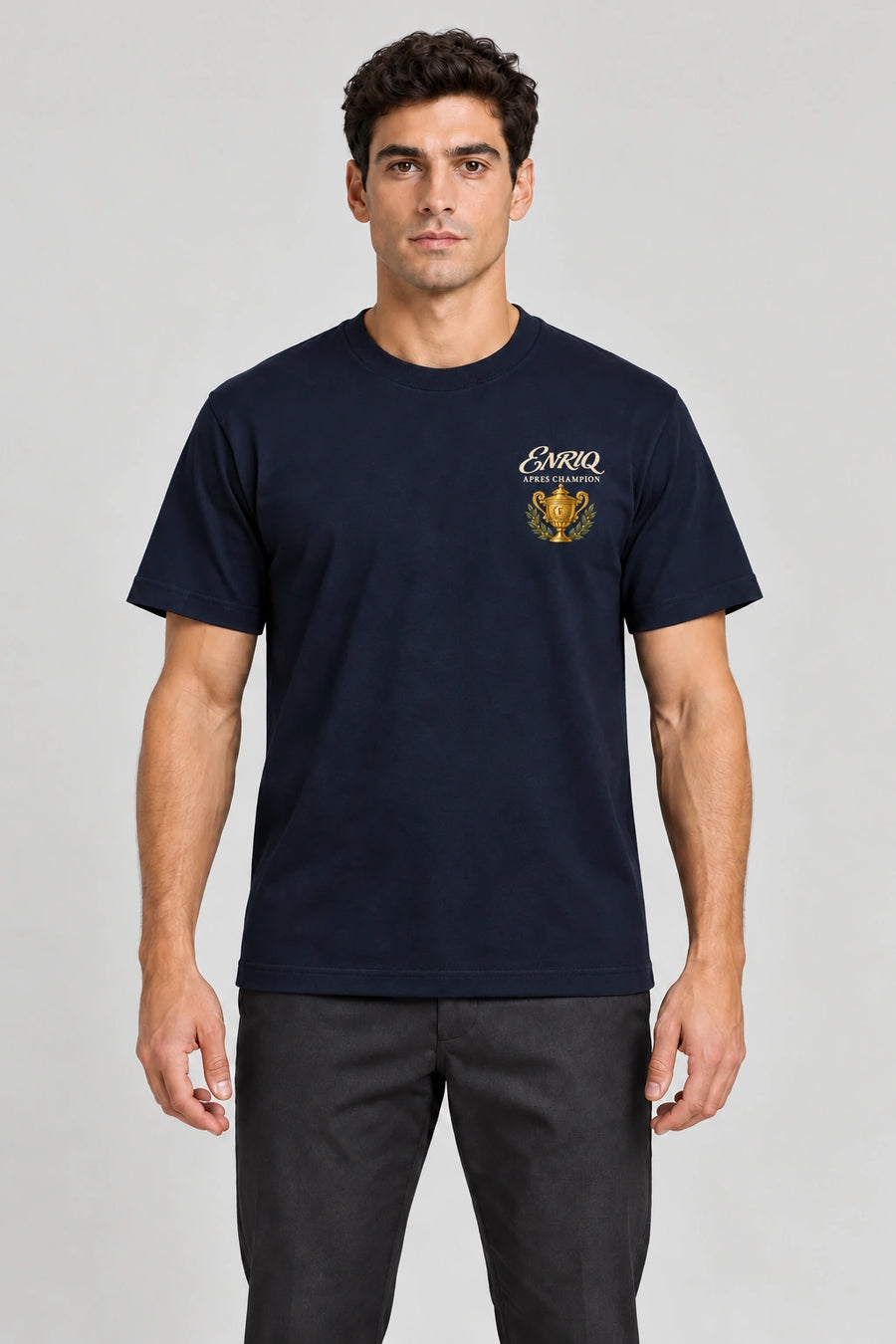 ENRIQ Apres Champion Tee Navy – op model met gouden trofee-borstlogo (AI-visualisatie)