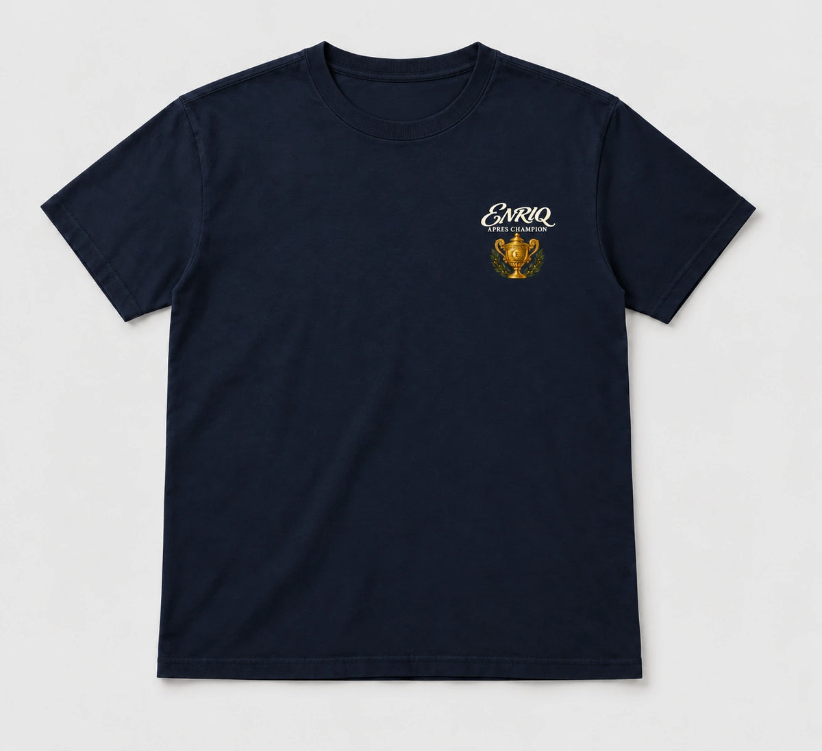ENRIQ Apres Champion Tee Navy – flatlay met gouden trofee-borstlogo (AI-visualisatie)