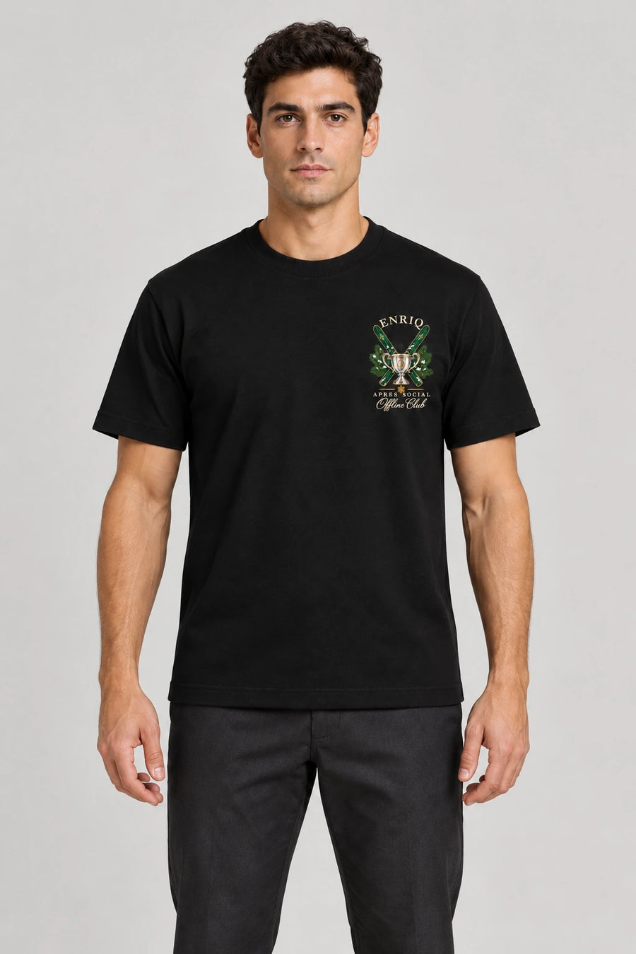 ENRIQ Apres Social Tee Black – voorkant op model met skis, trofee en Offline Club borstlogo (AI-visualisatie)