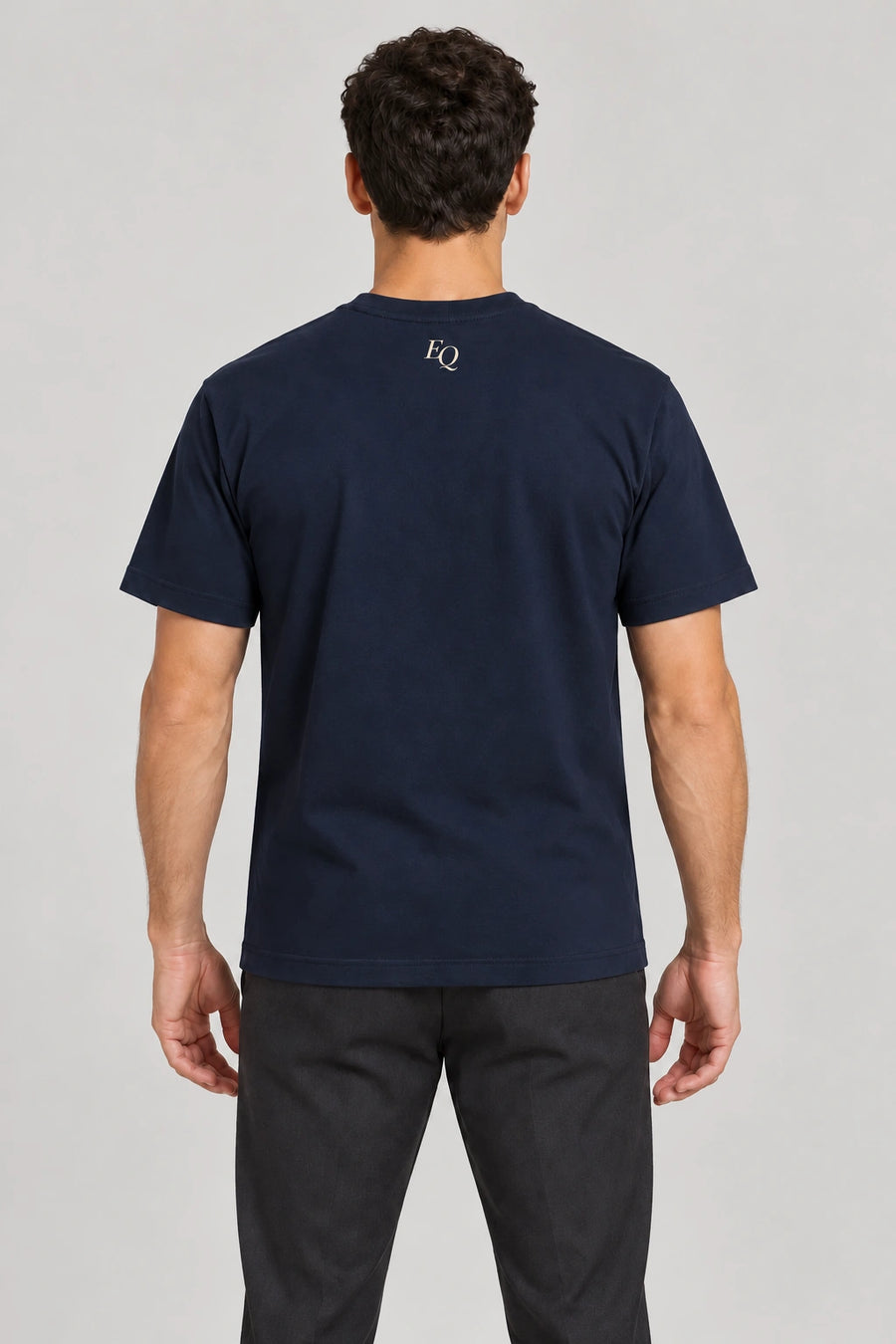 ENRIQ Atelier Signature Tee Navy – achterkant op model met klein EQ-neklogo (AI-visualisatie)