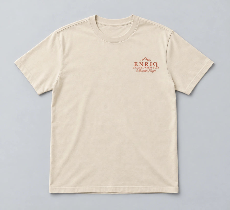 ENRIQ Chalet Owners Tee Bone – flatlay met bergtoppen en Chalet Owners Club borstlogo (AI-visualisatie)