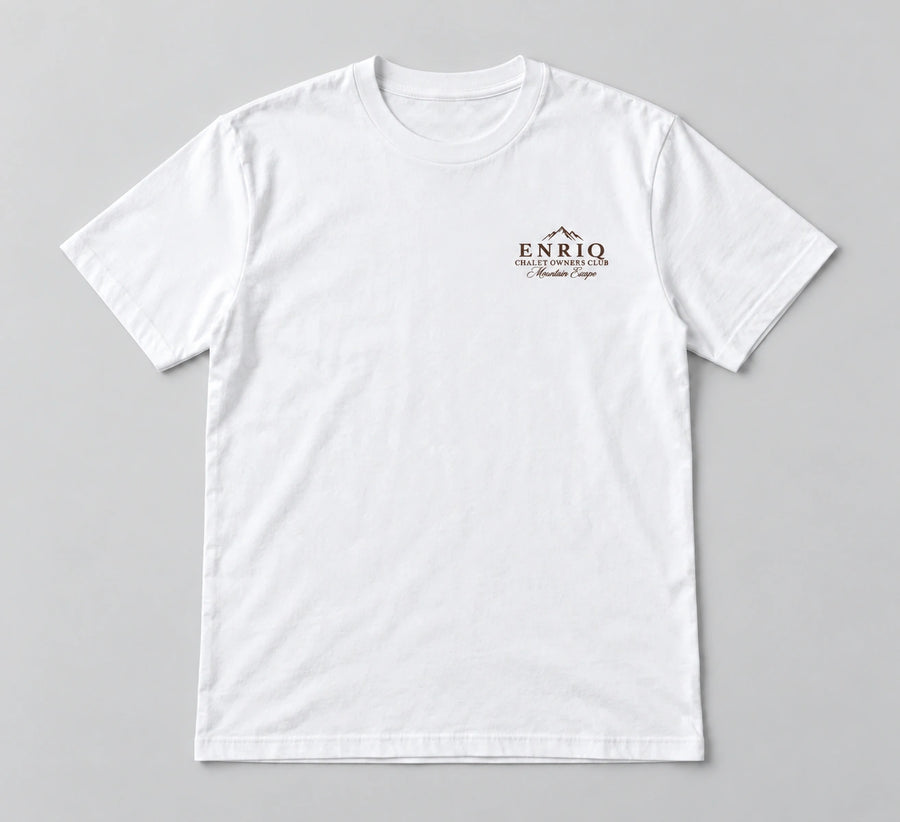 ENRIQ Chalet Owners Tee White – flatlay met bergtoppen en Chalet Owners Club borstlogo (AI-visualisatie)