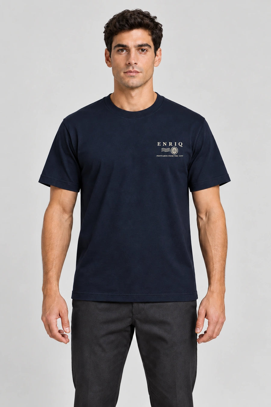 ENRIQ City Stamp Tee Navy – voorkant op model met ENRIQ poststempel-borstlogo (AI-visualisatie)